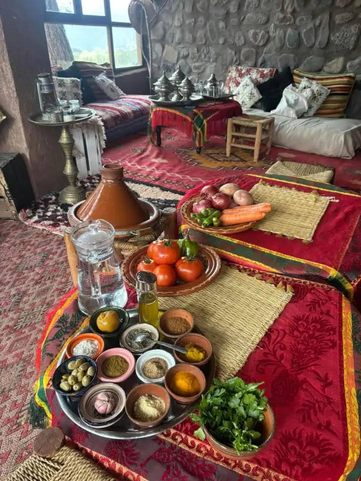 Salon traditionnel avec banquettes, tapis rouges et petit-déjeuner servi